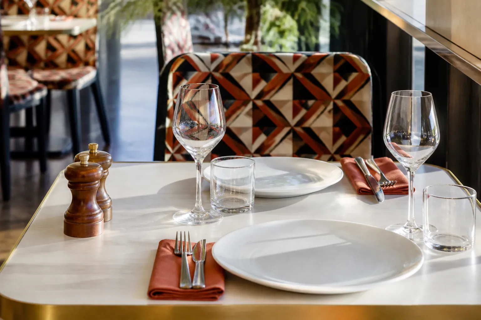 Table de brasserie dressée avec assiettes blanches et verres transparents